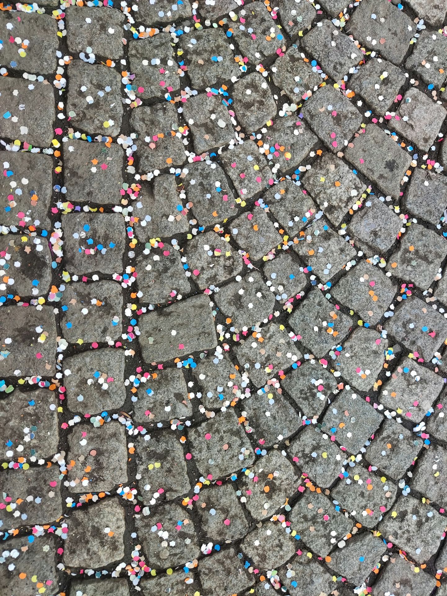 a close up of a cobblestone street with colorful sprinkles